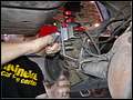 RE8003 Removing left rear lower control arm from axle.
